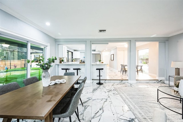 dining room featuring a wealth of natural light, marble finish floor, visible vents, and crown molding