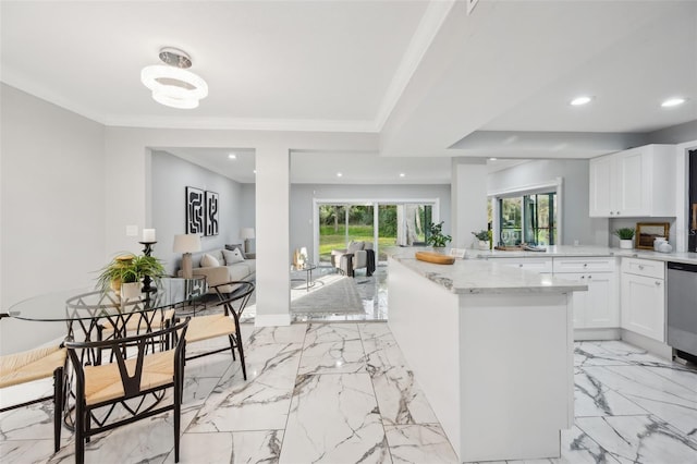 kitchen featuring light stone countertops, plenty of natural light, ornamental molding, and open floor plan