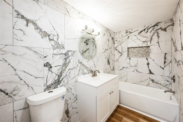 bathroom featuring toilet, tub / shower combination, a textured ceiling, vanity, and wood finished floors