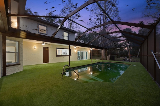 pool featuring a lanai, a patio area, a ceiling fan, and a lawn