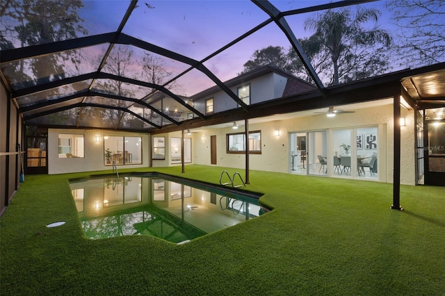 view of pool with ceiling fan, a lawn, a patio area, and a lanai