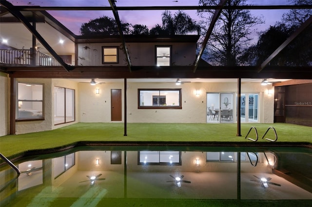 exterior space featuring a lawn, a patio area, a lanai, and stucco siding