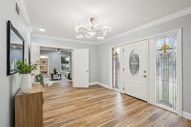 entryway featuring baseboards, crown molding, visible vents, and light wood finished floors