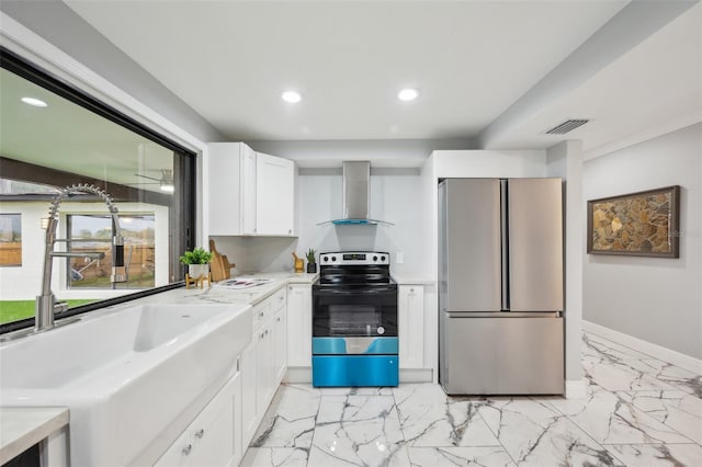 kitchen featuring visible vents, wall chimney exhaust hood, appliances with stainless steel finishes, light countertops, and a sink