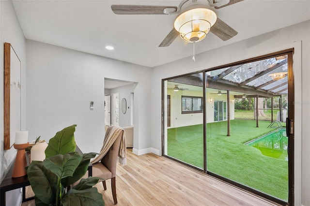 interior space with recessed lighting, a ceiling fan, a sunroom, baseboards, and light wood-type flooring