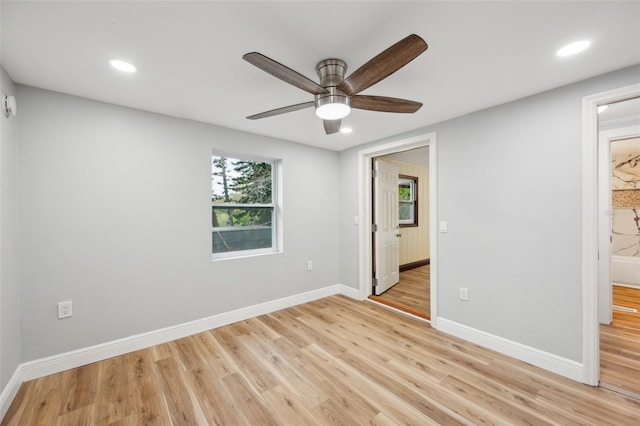 spare room featuring recessed lighting, light wood-type flooring, a ceiling fan, and baseboards