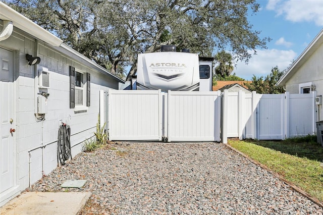 view of side of home featuring a gate and fence