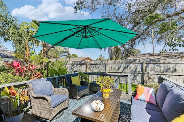 wooden deck with outdoor lounge area and a fenced backyard