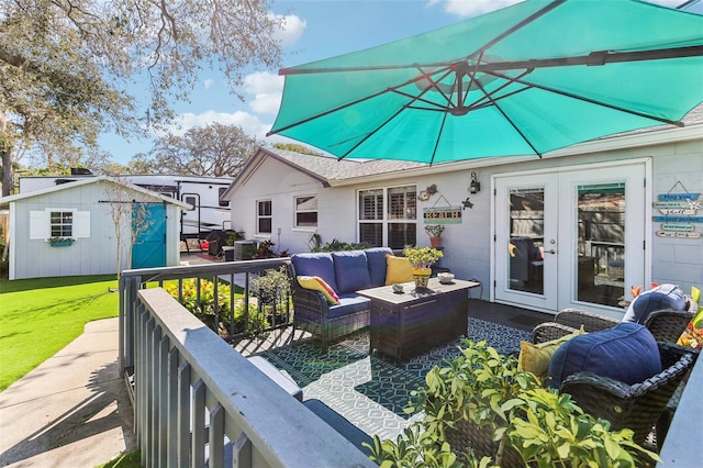 wooden deck with french doors, an outbuilding, a storage unit, a yard, and outdoor lounge area