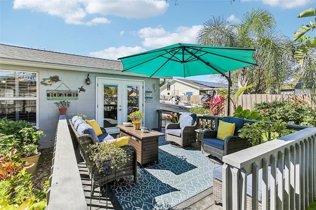 view of patio / terrace with french doors, fence, and an outdoor living space