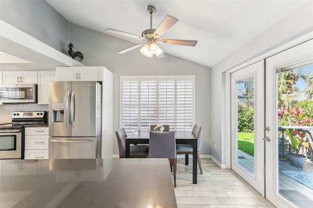 kitchen featuring white cabinets, decorative backsplash, dark countertops, appliances with stainless steel finishes, and french doors