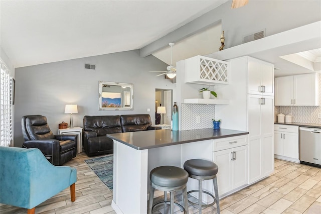 kitchen featuring wood finish floors, visible vents, stainless steel dishwasher, open shelves, and dark countertops