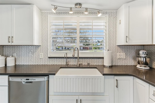 kitchen featuring dishwasher, dark countertops, backsplash, white cabinetry, and a sink