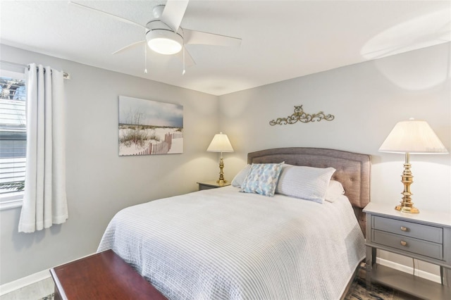 bedroom featuring a ceiling fan, baseboards, and wood finished floors