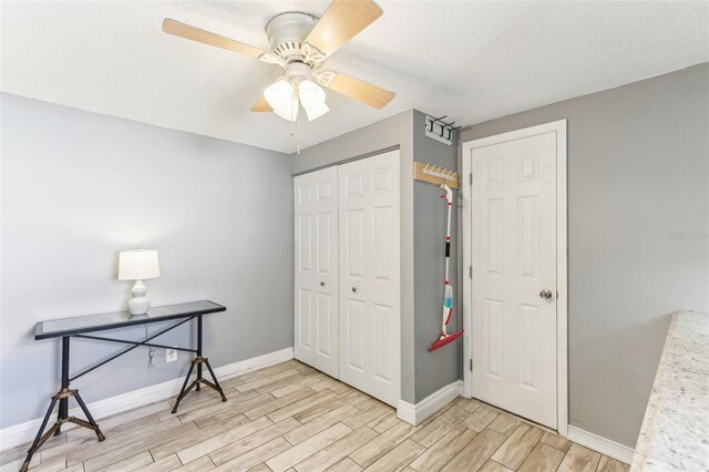 bedroom with baseboards, a closet, a ceiling fan, and wood tiled floor