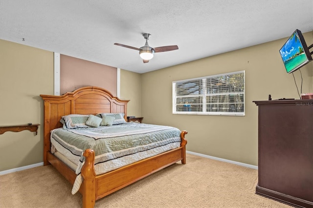 carpeted bedroom with ceiling fan, baseboards, and a textured ceiling