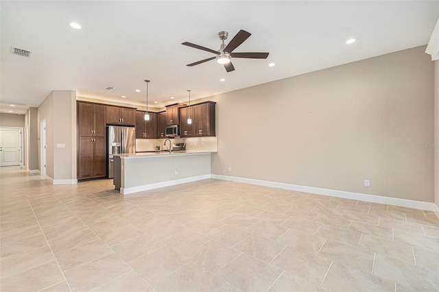 kitchen featuring stainless steel appliances, light countertops, visible vents, a ceiling fan, and open floor plan