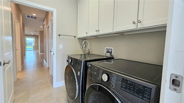 washroom featuring light tile patterned floors, visible vents, cabinet space, separate washer and dryer, and baseboards