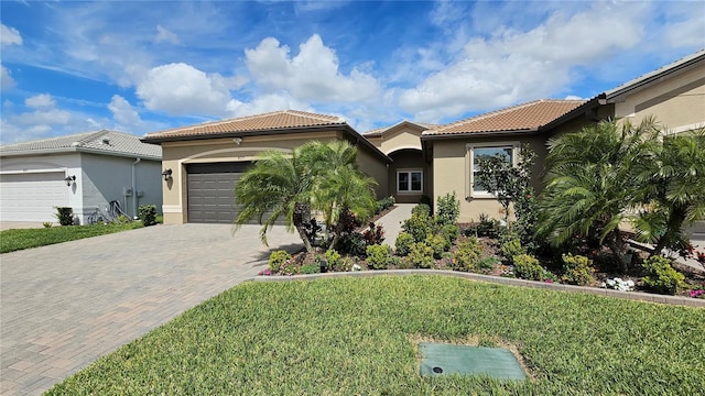 mediterranean / spanish-style house with a tiled roof, decorative driveway, an attached garage, and stucco siding