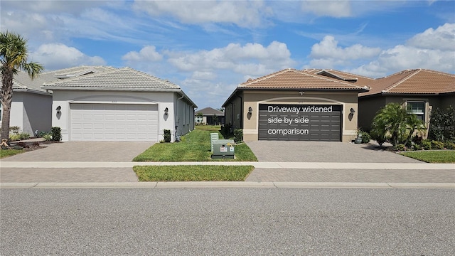 view of front of house featuring decorative driveway, a tile roof, an attached garage, and stucco siding