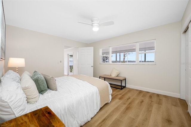 bedroom with a closet, baseboards, light wood-style flooring, and a ceiling fan