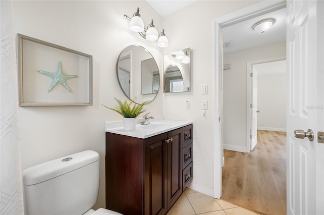 bathroom featuring baseboards, toilet, vanity, and tile patterned flooring