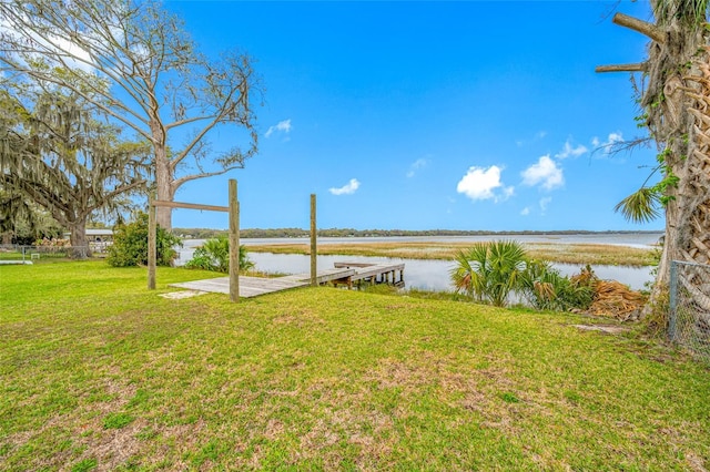 dock area with a water view and a lawn