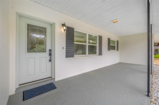 doorway to property featuring stucco siding