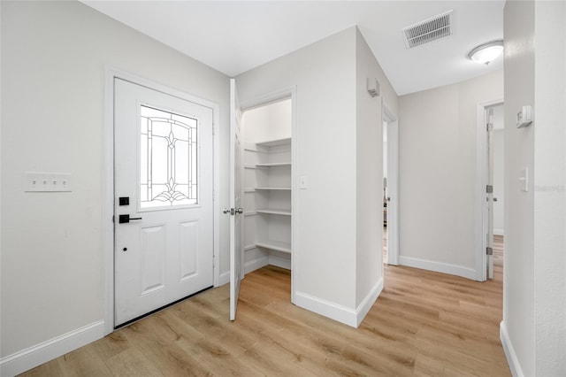 foyer entrance with visible vents, light wood-type flooring, and baseboards