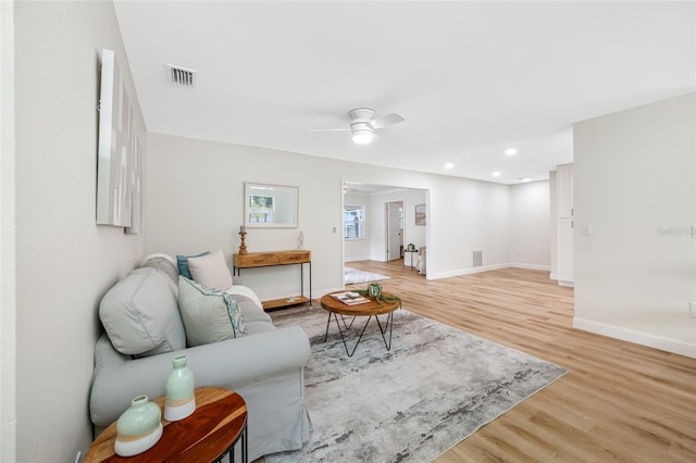 living room featuring light wood-type flooring, visible vents, recessed lighting, baseboards, and ceiling fan