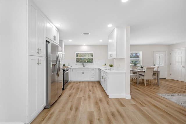 kitchen featuring light wood finished floors, visible vents, light countertops, appliances with stainless steel finishes, and white cabinetry