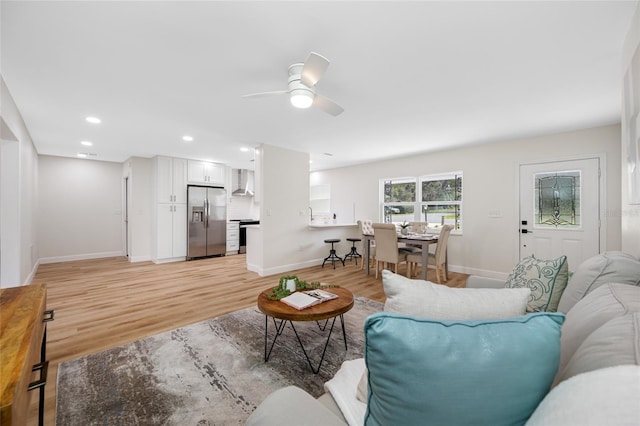 living area with recessed lighting, light wood-type flooring, and baseboards