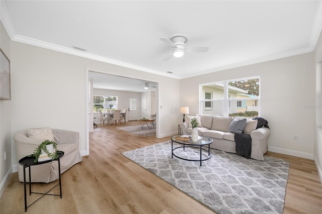 living area featuring crown molding, light wood-style floors, visible vents, and baseboards