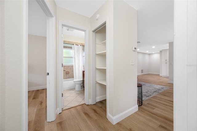 hallway with baseboards and light wood-type flooring