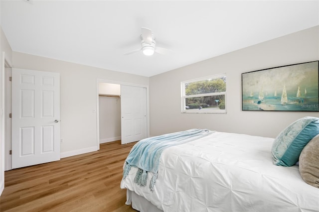 bedroom featuring a closet, baseboards, light wood-style floors, and a ceiling fan