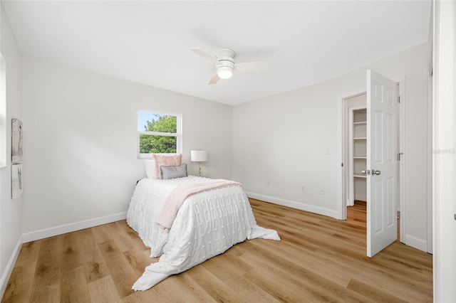 bedroom with ceiling fan, baseboards, and wood finished floors