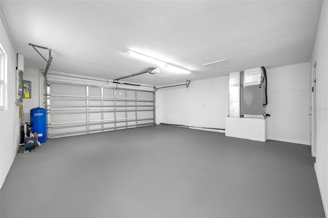 garage featuring heating unit and a garage door opener