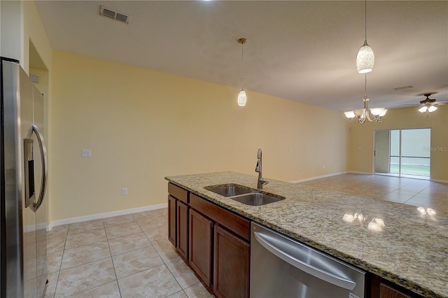 kitchen featuring light tile patterned floors, stainless steel appliances, a sink, visible vents, and hanging light fixtures