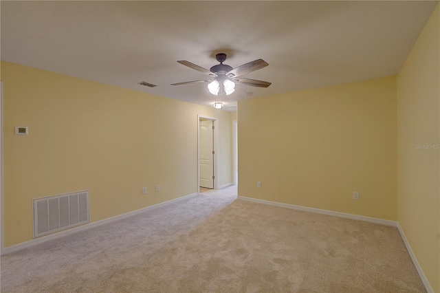 unfurnished room featuring light colored carpet, visible vents, ceiling fan, and baseboards