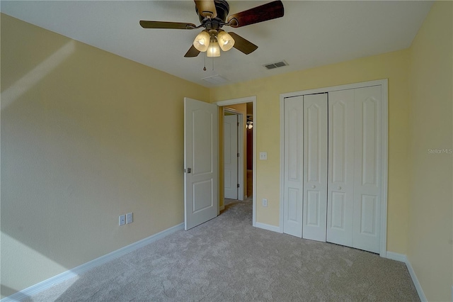 unfurnished bedroom featuring carpet floors, a closet, visible vents, ceiling fan, and baseboards