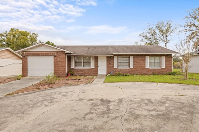 single story home featuring a garage, concrete driveway, and brick siding