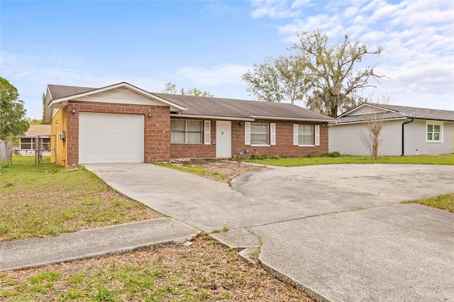 ranch-style home with driveway, brick siding, an attached garage, fence, and a front yard