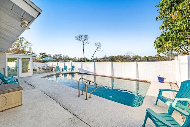 view of pool featuring a patio area, a fenced backyard, outdoor dining area, and a fenced in pool