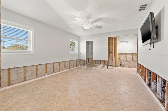 unfurnished room featuring visible vents, ceiling fan, and a textured ceiling