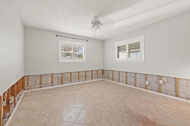 spare room with a ceiling fan and a textured ceiling