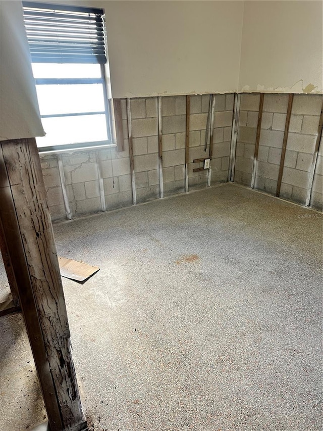 empty room featuring speckled floor and concrete block wall