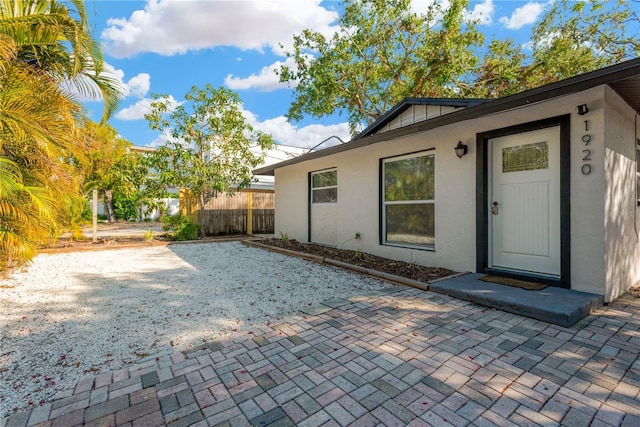 back of house featuring a patio area, fence, and stucco siding