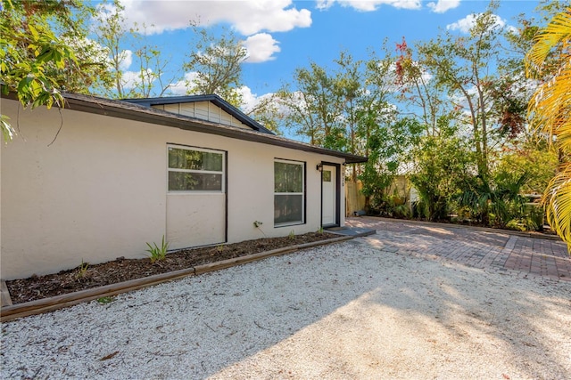 rear view of property with a patio area, fence, and stucco siding