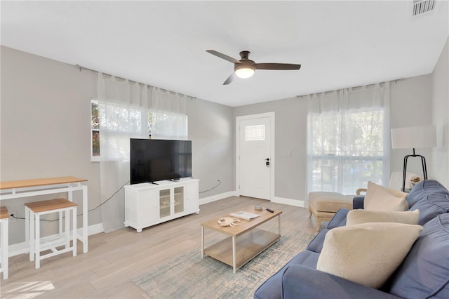 living area featuring a healthy amount of sunlight, visible vents, and wood finished floors