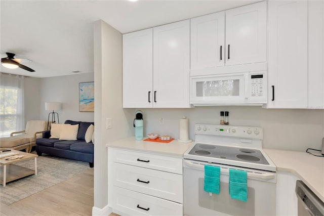 kitchen with white appliances, white cabinets, light wood-style flooring, open floor plan, and light countertops